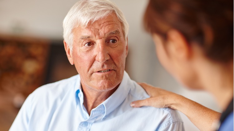 Doctor talks to elderly male patient