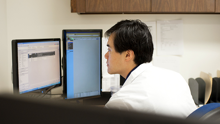 Doctor in white coat at computer