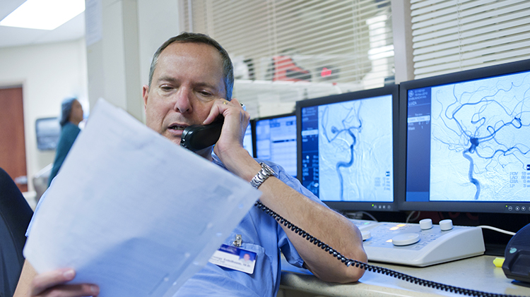 Doctor on phone looking at medical imaging