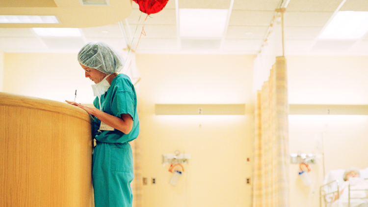 Dr in green scrubs takes notes