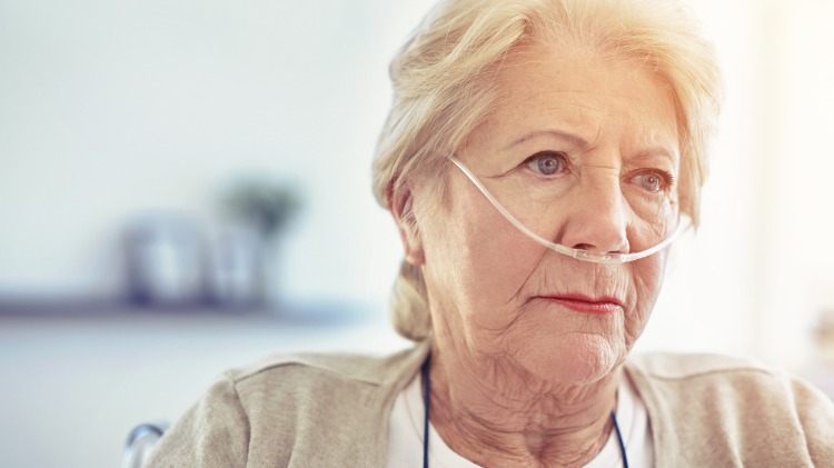 Senior female patient with breathing tubes