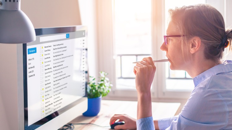 Woman sitting at a computer contemplatively