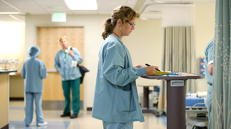 Doctor doing hospital rounds at patients' bed