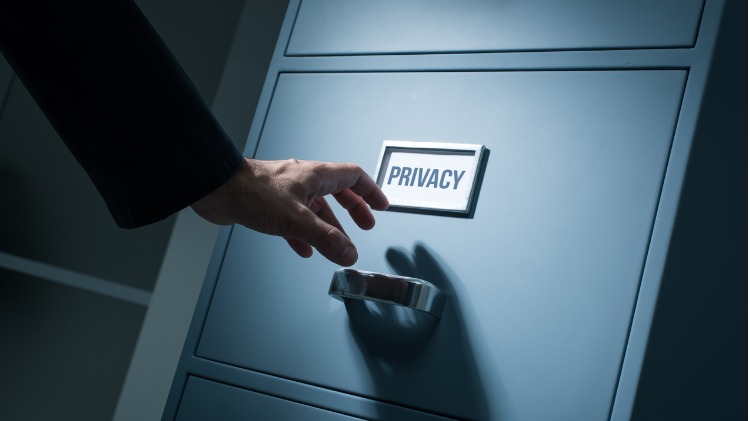 Hand reaches toward a filing cabinet with PRIVACY written in bold 