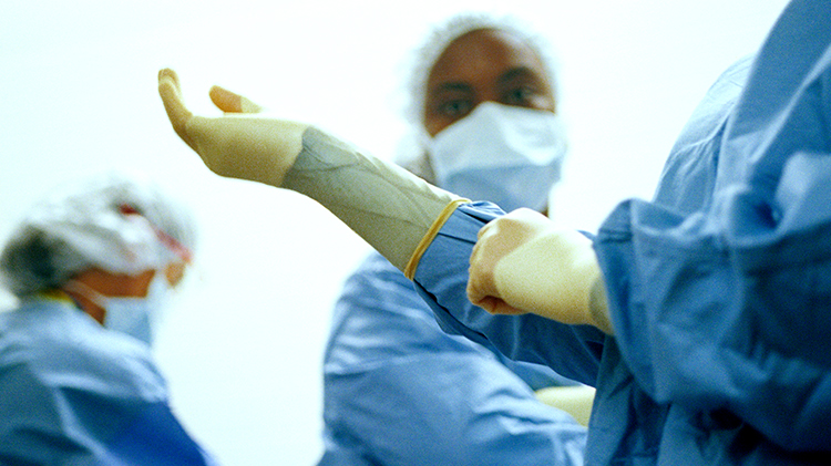 Doctor pulling on rubber gloves