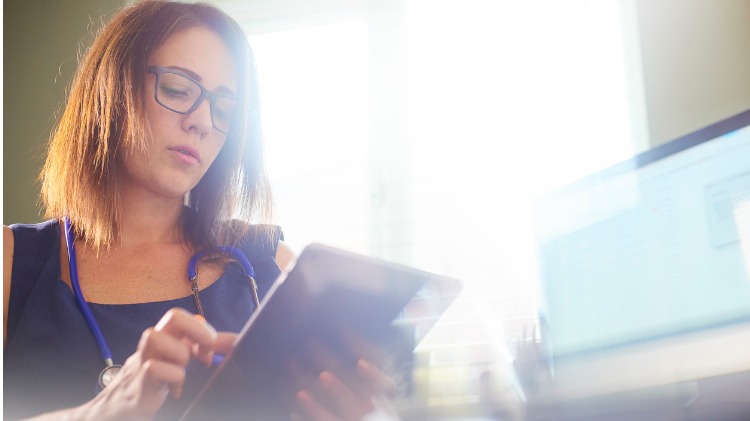 Doctor reading information on a tablet