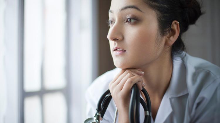 Young female doctor looks pensive