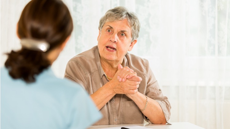 Sitting in conversation with a senior woman